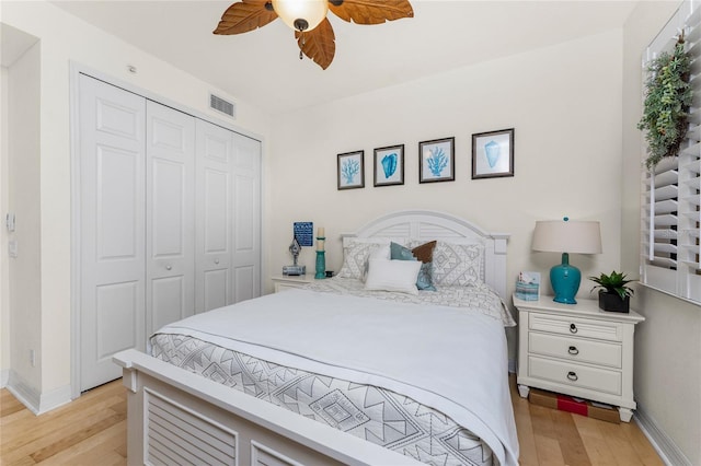 bedroom with ceiling fan, visible vents, baseboards, a closet, and light wood-style flooring