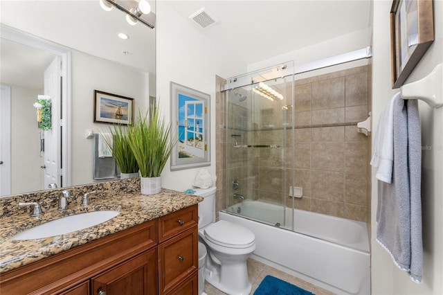 full bathroom featuring vanity, toilet, tile patterned floors, combined bath / shower with glass door, and visible vents