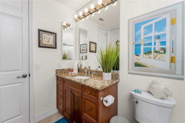 bathroom with vanity, toilet, tile patterned floors, baseboards, and visible vents