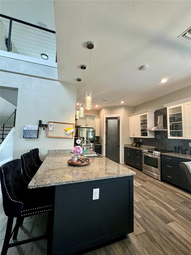 22223 Seyburn Ter, Port Charlotte, FL 33954 - kitchen with stainless steel electric stove, dark wood finished floors, wall chimney range hood, white cabinetry, and backsplash