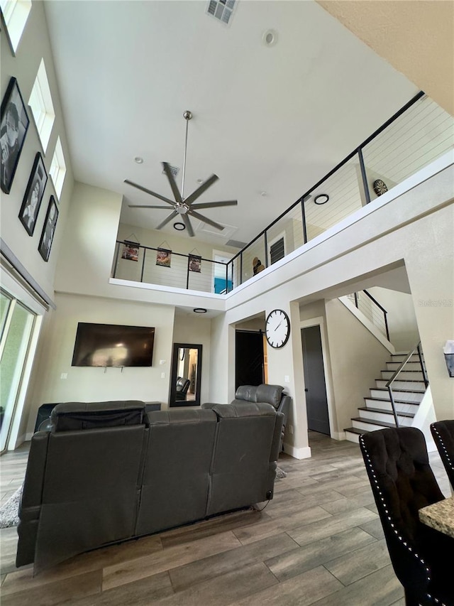 22223 Seyburn Ter, Port Charlotte, FL 33954 - living room with a high ceiling, a ceiling fan, stairs, visible vents, and wood finished floors