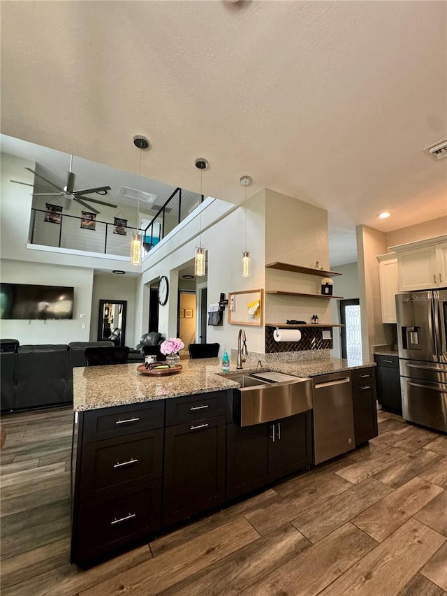 22223 Seyburn Ter, Port Charlotte, FL 33954 - kitchen with light stone countertops, wood finish floors, a ceiling fan, a sink, and stainless steel appliances