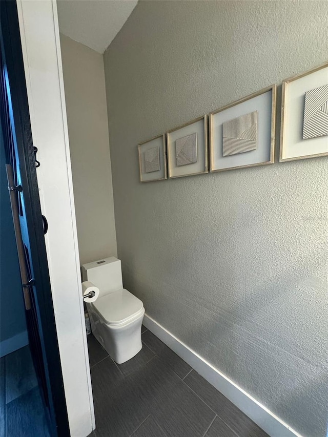 22223 Seyburn Ter, Port Charlotte, FL 33954 - bathroom featuring toilet, a textured wall, and baseboards