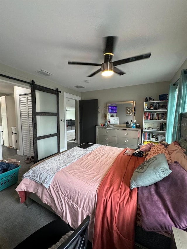 22223 Seyburn Ter, Port Charlotte, FL 33954 - bedroom with freestanding refrigerator, ceiling fan, visible vents, a barn door, and carpet flooring