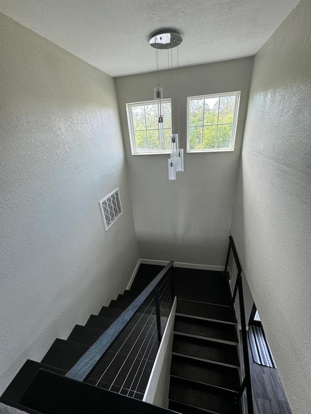 22223 Seyburn Ter, Port Charlotte, FL 33954 - staircase featuring a textured wall, visible vents, and a textured ceiling