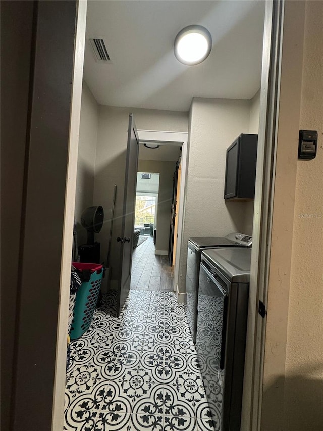 22223 Seyburn Ter, Port Charlotte, FL 33954 - laundry area featuring light tile patterned floors, visible vents, independent washer and dryer, and cabinet space