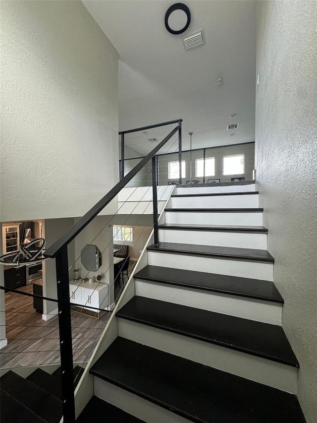 22223 Seyburn Ter, Port Charlotte, FL 33954 - staircase with visible vents, wood finished floors, and a textured wall