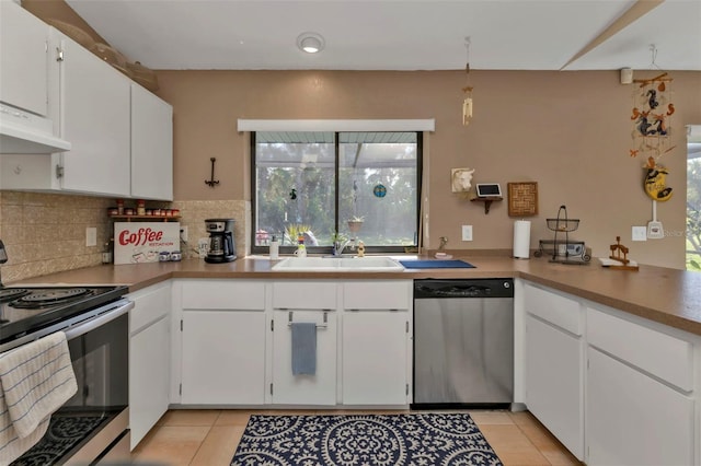 4420 Larkspur Ct, Port Charlotte, FL 33948 - kitchen with white cabinetry, tasteful backsplash, light tile patterned floors, stainless steel appliances, and a sink