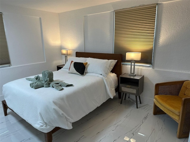 bedroom with a textured wall and marble finish floor