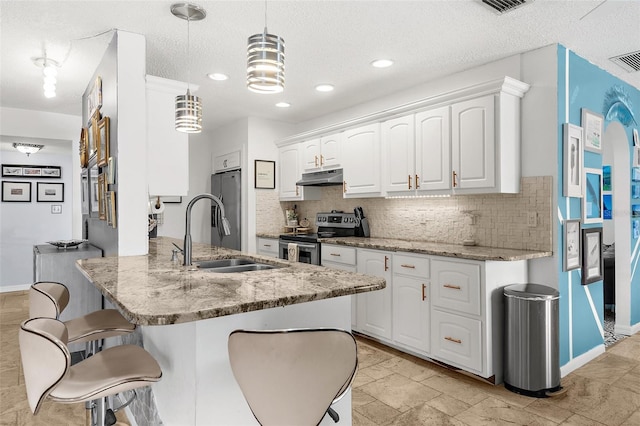 4168 Harbor Blvd, Port Charlotte, FL 33952 - kitchen with white cabinets, under cabinet range hood, a sink, tasteful backsplash, and appliances with stainless steel finishes