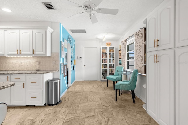 4168 Harbor Blvd, Port Charlotte, FL 33952 - interior space with a ceiling fan, a textured ceiling, white cabinets, backsplash, and visible vents