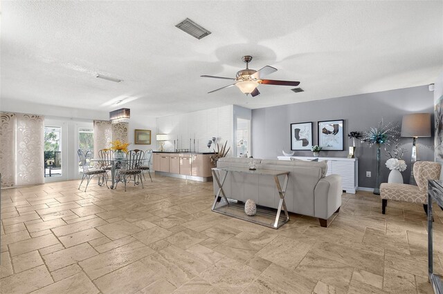 4168 Harbor Blvd, Port Charlotte, FL 33952 - living room with baseboards, a ceiling fan, visible vents, and a textured ceiling