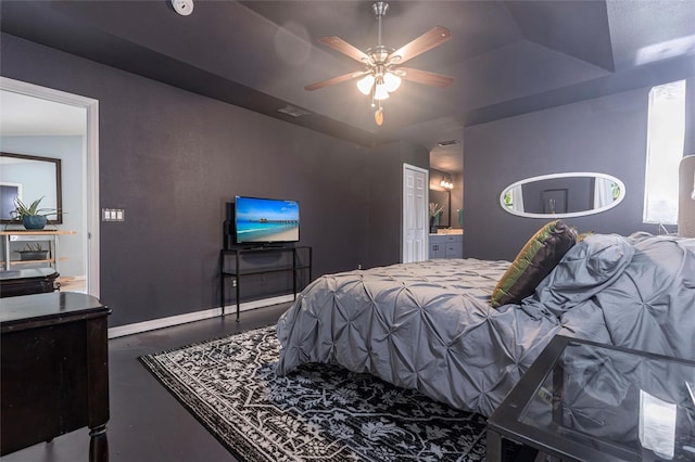 2661 30th Ave SE, Naples, FL 34117 - bedroom with concrete floors, ensuite bathroom, baseboards, a raised ceiling, and a ceiling fan