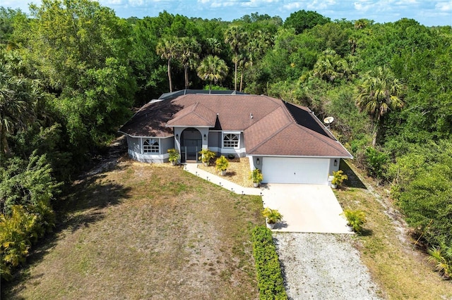 2661 30th Ave SE, Naples, FL 34117 - view of front of property with an attached garage, a view of trees, and gravel driveway