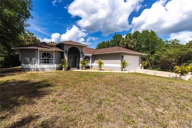 2661 30th Ave SE, Naples, FL 34117 - view of front of house featuring a front yard, an attached garage, stucco siding, and concrete driveway