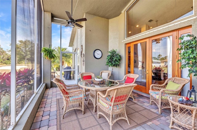 sunroom / solarium with french doors, outdoor dining space, a textured ceiling, and ceiling fan