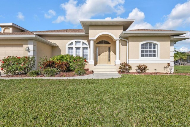 235 Tournament Rd, Rotonda West, FL 33947 - view of front of property with a front lawn, a garage, and stucco siding
