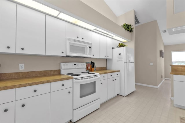 235 Tournament Rd, Rotonda West, FL 33947 - kitchen with white cabinets, baseboards, light countertops, white appliances, and vaulted ceiling