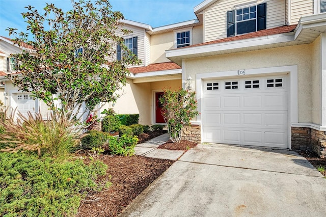 1156 Jonah Dr, North Port, FL 34289 - view of front of house featuring stone siding, driveway, stucco siding, and an attached garage
