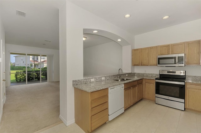 1156 Jonah Dr, North Port, FL 34289 - kitchen featuring a sink, light stone countertops, stainless steel appliances, light colored carpet, and recessed lighting