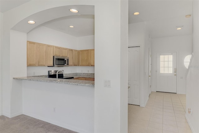 1156 Jonah Dr, North Port, FL 34289 - kitchen featuring recessed lighting, light tile patterned flooring, arched walkways, light brown cabinets, and appliances with stainless steel finishes