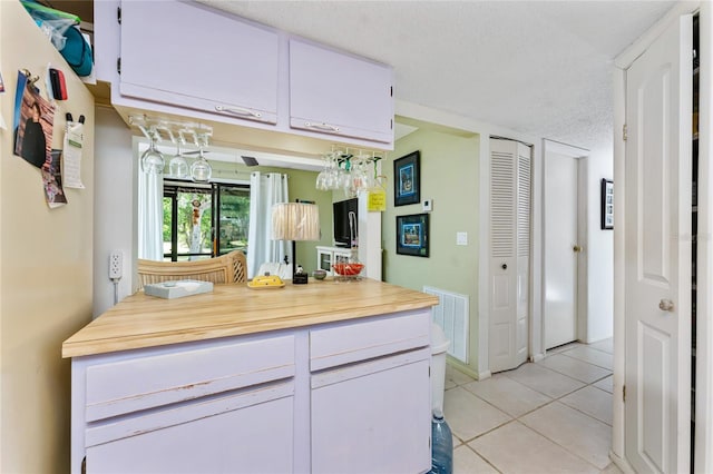 4022 Beaver Ln Unit 500C, Port Charlotte, FL 33952 - kitchen with light tile patterned flooring, white cabinets, freestanding refrigerator, and light countertops