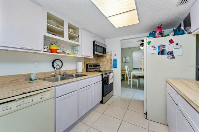 4022 Beaver Ln Unit 500C, Port Charlotte, FL 33952 - kitchen with stainless steel appliances, a sink, ceiling fan, light tile patterned flooring, and decorative backsplash