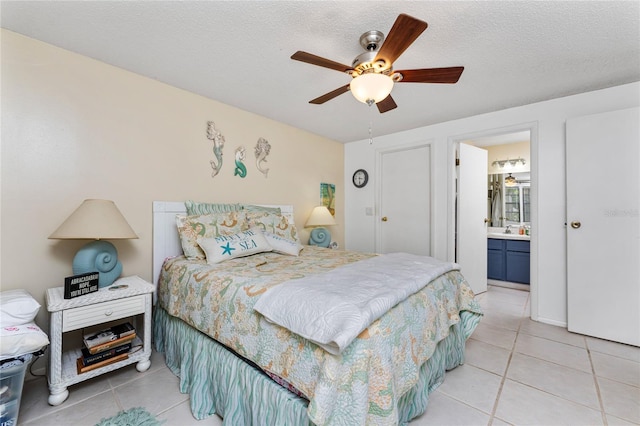 4022 Beaver Ln Unit 500C, Port Charlotte, FL 33952 - bedroom featuring light tile patterned flooring, a textured ceiling, ensuite bathroom, a ceiling fan, and a sink
