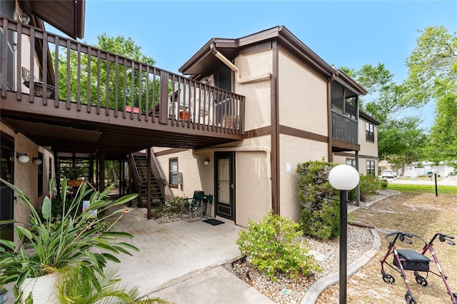 4022 Beaver Ln Unit 500C, Port Charlotte, FL 33952 - rear view of property featuring stucco siding, stairway, a patio area, and a deck