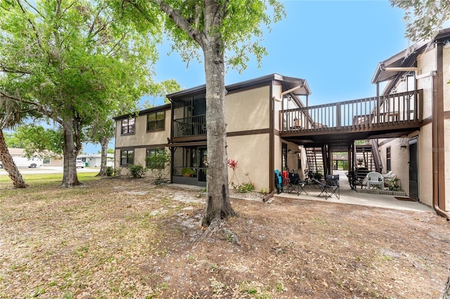 4022 Beaver Ln Unit 500C, Port Charlotte, FL 33952 - back of house featuring stairway, a patio area, stucco siding, and a deck