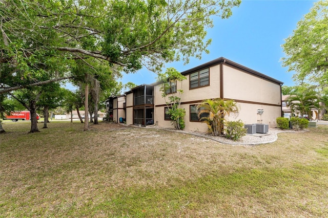4022 Beaver Ln Unit 500C, Port Charlotte, FL 33952 - rear view of house featuring stucco siding, a yard, and cooling unit