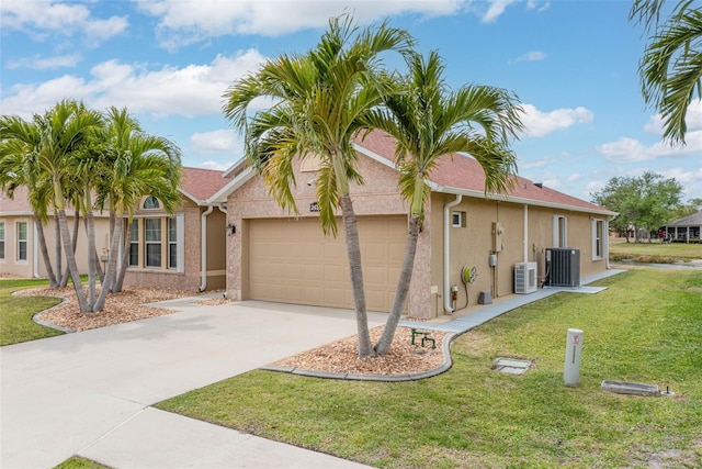2699 Suncoast Lakes Blvd, Punta Gorda, FL 33980 - ranch-style house featuring driveway, central AC unit, a garage, a front yard, and stucco siding
