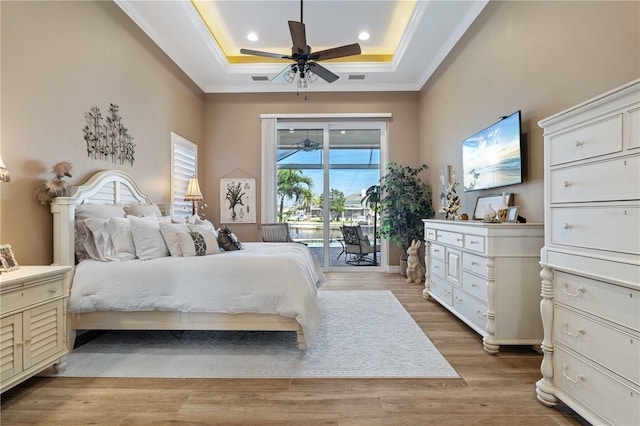 bedroom featuring light wood finished floors, ornamental molding, access to outside, recessed lighting, and a raised ceiling