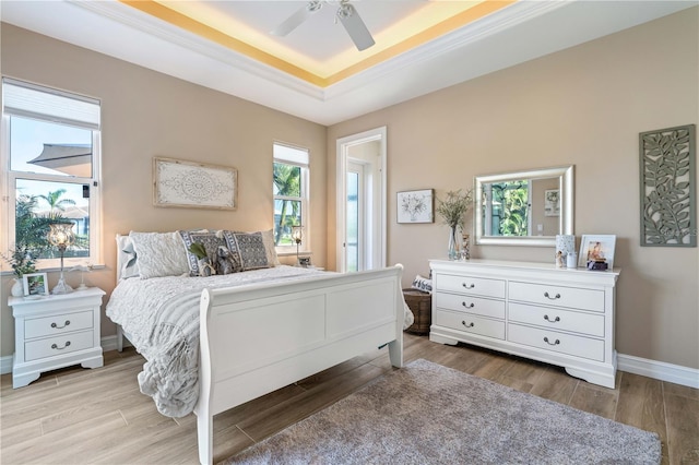 bedroom featuring baseboards, ceiling fan, wood finished floors, and a raised ceiling