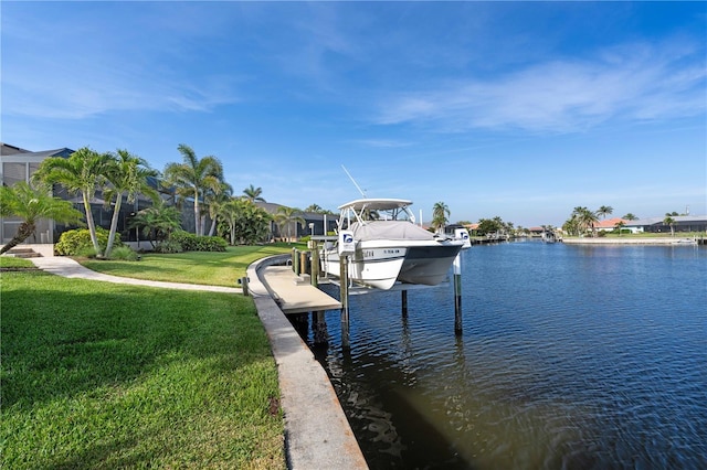 dock area with a water view, a lawn, and boat lift