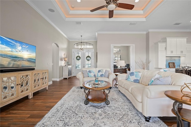 347 Portofino Dr, Punta Gorda, FL 33950 - living room featuring dark wood-type flooring, ceiling fan, a tray ceiling, arched walkways, and ornamental molding