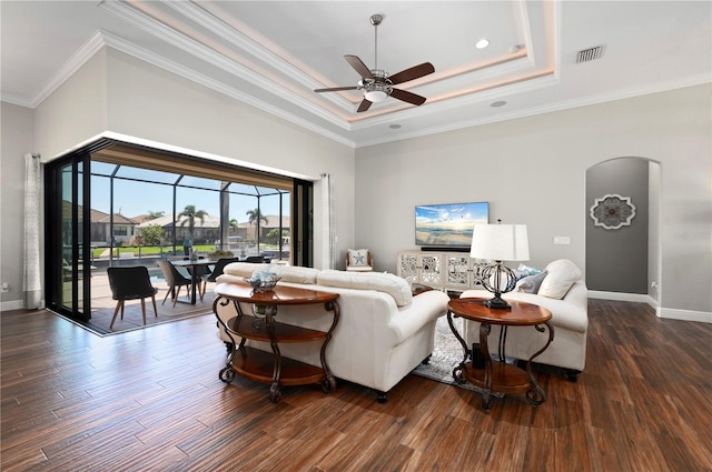 347 Portofino Dr, Punta Gorda, FL 33950 - living area featuring ceiling fan, arched walkways, a raised ceiling, dark wood-style floors, and ornamental molding