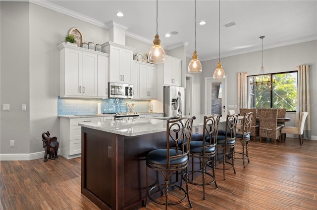 347 Portofino Dr, Punta Gorda, FL 33950 - kitchen with appliances with stainless steel finishes, decorative backsplash, crown molding, a large island with sink, and dark wood-style flooring