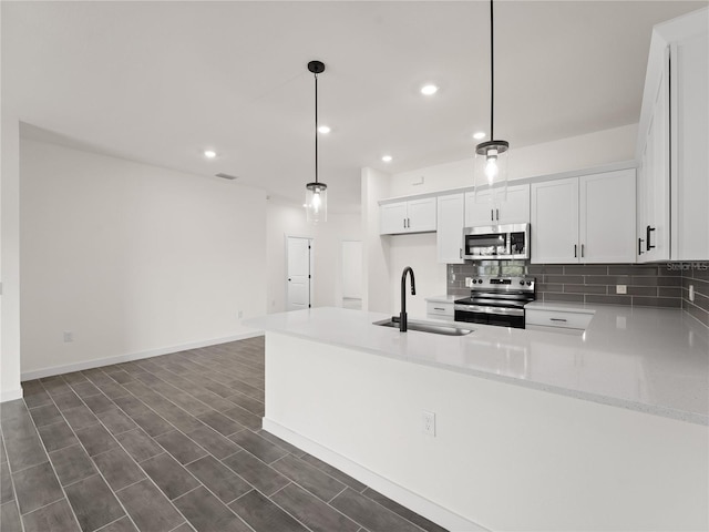 14449 Appleton Blvd, Port Charlotte, FL 33981 - kitchen featuring stainless steel appliances, tasteful backsplash, white cabinetry, a peninsula, and recessed lighting