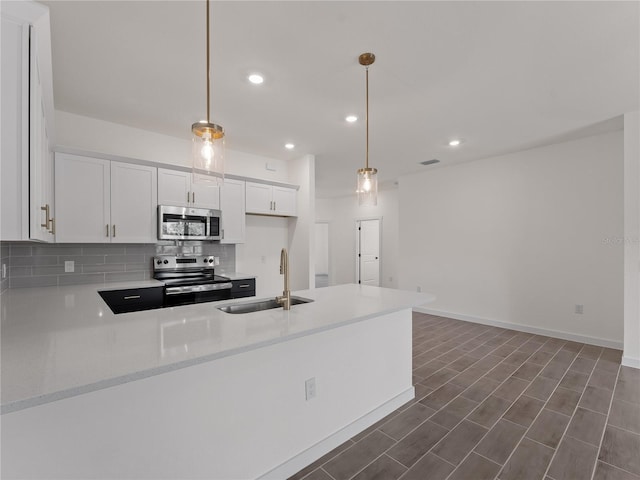 14449 Appleton Blvd, Port Charlotte, FL 33981 - kitchen with appliances with stainless steel finishes, a peninsula, backsplash, white cabinetry, and recessed lighting