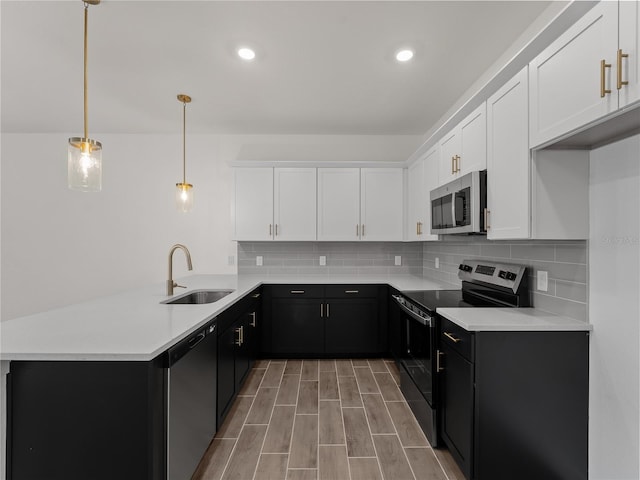 14449 Appleton Blvd, Port Charlotte, FL 33981 - kitchen featuring appliances with stainless steel finishes, a peninsula, white cabinets, tasteful backsplash, and dark cabinets