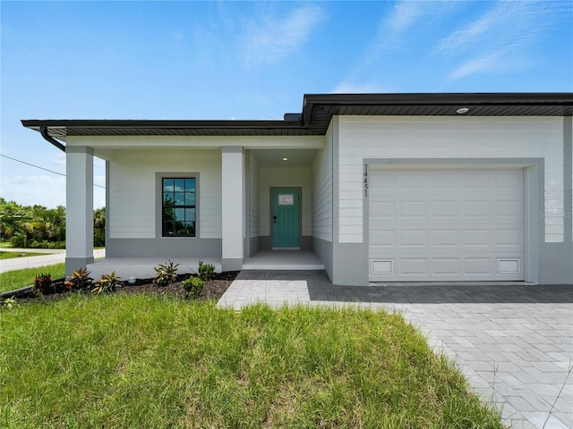 14449 Appleton Blvd, Port Charlotte, FL 33981 - view of front of home with a garage, decorative driveway, and a porch