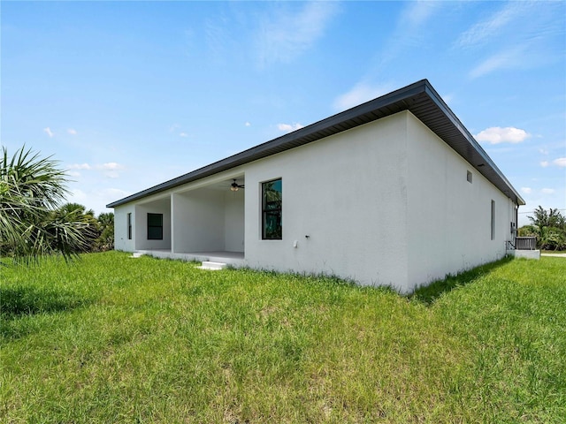 14449 Appleton Blvd, Port Charlotte, FL 33981 - rear view of house with a ceiling fan, stucco siding, and a lawn