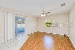 23482 Moreland Ave, Port Charlotte, FL 33954 - spare room with visible vents, wood finished floors, a healthy amount of sunlight, and a ceiling fan