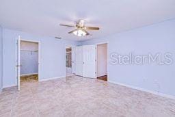 23482 Moreland Ave, Port Charlotte, FL 33954 - unfurnished bedroom with a ceiling fan, a walk in closet, and a closet