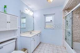 23482 Moreland Ave, Port Charlotte, FL 33954 - full bathroom featuring enclosed tub / shower combo, toilet, and vanity