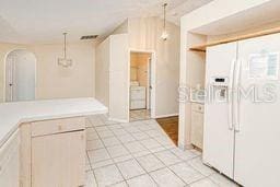 23482 Moreland Ave, Port Charlotte, FL 33954 - kitchen featuring light countertops, arched walkways, white fridge with ice dispenser, and pendant lighting