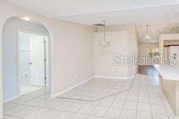 23482 Moreland Ave, Port Charlotte, FL 33954 - empty room featuring tile patterned floors, arched walkways, and baseboards