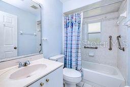 23482 Moreland Ave, Port Charlotte, FL 33954 - full bath featuring toilet, shower / bath combination with curtain, and vanity