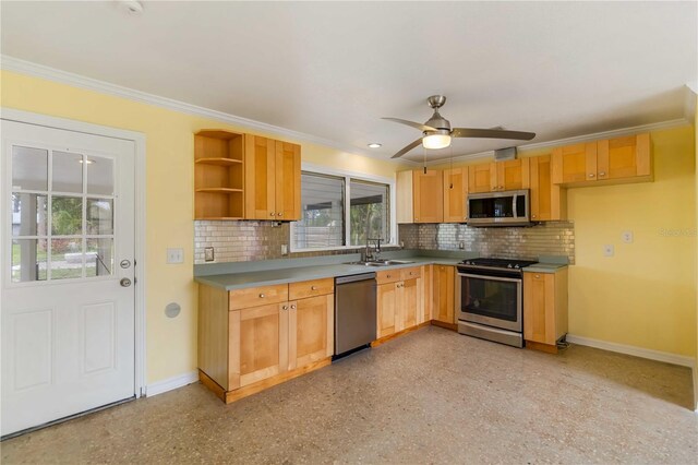 217 Palm Ave E, Nokomis, FL 34275 - kitchen featuring stainless steel appliances, a sink, baseboards, ornamental molding, and decorative backsplash
